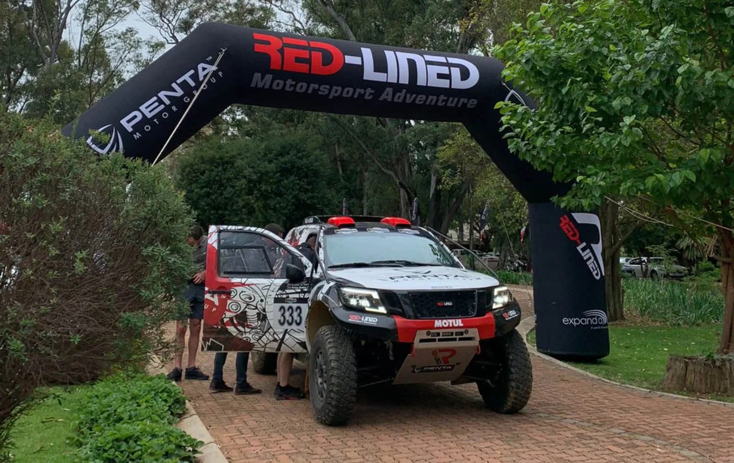Red-Lined and Penta rally bakkies staged under the Red-Lined arch at a corporate day